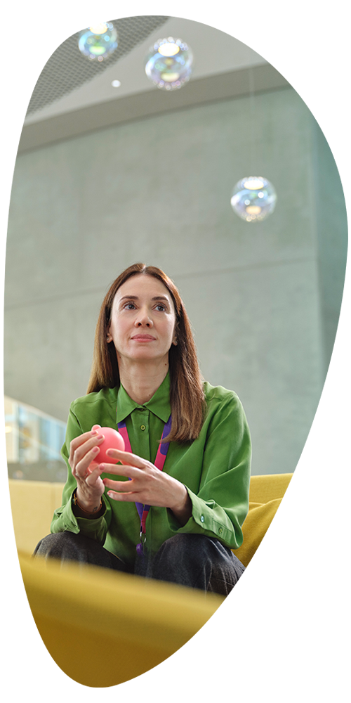 EMD Serono employee, sitting in a lounge area, looking off into the distance